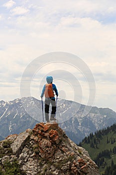 Backpacker hiking on mountain peak cliff