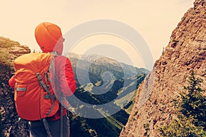 Backpacker hiking on mountain peak cliff