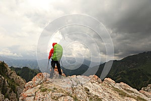Backpacker hiking on mountain peak cliff