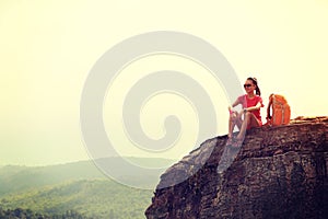 Backpacker hiking on mountain peak cliff