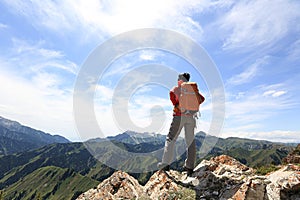 Backpacker hiking on mountain peak cliff