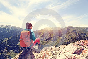 backpacker hiking on mountain peak cliff