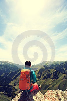 backpacker hiking on mountain peak cliff
