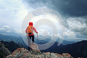 backpacker hiking on mountain peak cliff
