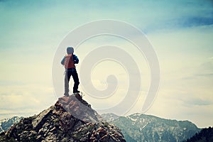 backpacker hiking on mountain peak cliff