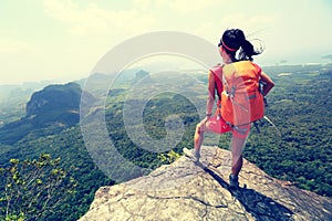 Backpacker hiking on mountain peak cliff