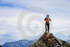 Backpacker hiking on mountain peak cliff