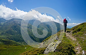 Backpacker hiking on a path in the mountains