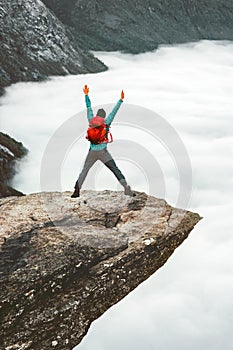 Backpacker Man jumping on Trolltunga rocky cliff edge