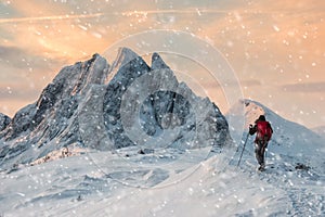 Backpacker mountaineer hiking on snow hill with majestic mount w