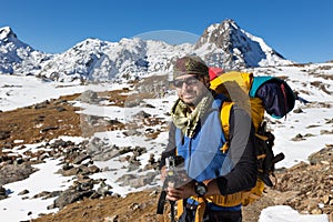 Backpacker mountaineer man portrait standing rest snow mountain.