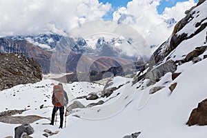Backpacker mountaineer standing snow mountain pass above glacier