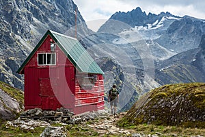 Backpacker Next to Wilderness Hut in Talkeetna Mountains, Alaska