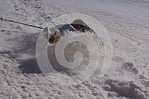 Backpacker slipping on wet snow and falling down a slope