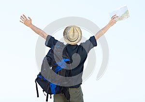 Backpacker standing with arms outstretched