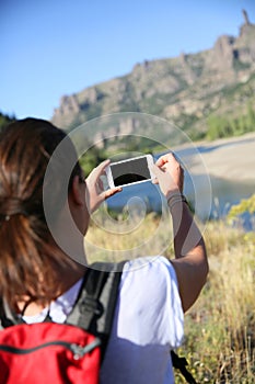 Backpacker taking photo with smartphone in Patagonia
