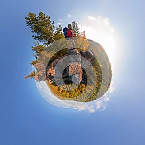 Backpacker on top of a rock fall at dawn. spherical degree panorama 360 180 little planet