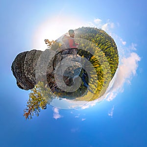 Backpacker on top of a rock fall at dawn. spherical degree panorama 360 180 little planet