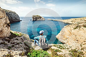 Backpacker traveler relax on the rocky coast of blue sea lagoon