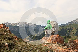 Backpacker use digital tablet on mountain peak cliff