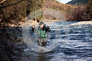 Backpacker wade rugged river