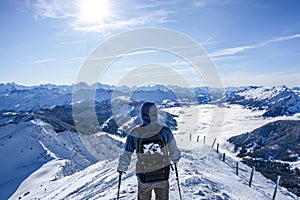 backpacker walking on the ridge at the summit of the snow covered mountain. beautiful winter mountain panorama layers. sunny day,