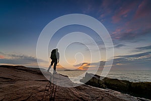 Backpacker watching a sunrise at Acadia National Park