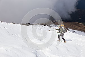 Backpacker woman ascending hiking walking snow mountain.