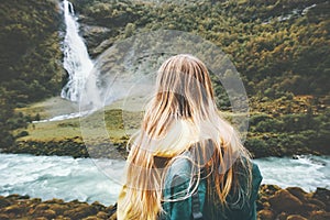 Backpacker woman enjoying waterfall and forest landscape