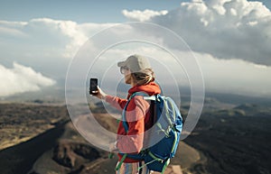 Backpacker woman taking photo with smart phone