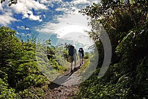 Backpackers hiking uphill mountain trail