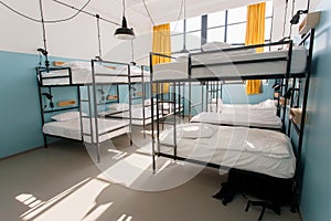 Backpackers hostel with modern bunk beds in dorm room for twelve people