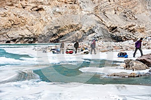 Backpackers and porters walking on frozen Zanskar river. Chadar Trek. Leh. India