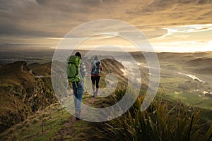 Backpackers walking on a mountain at sunrise. Travel concept