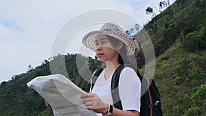 Backpacking female hiker stands on top of the mountain with raised arms and enjoying the view. journey and success concept