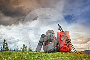 Backpacks in the mountains overlooking the mountains on the green grass.