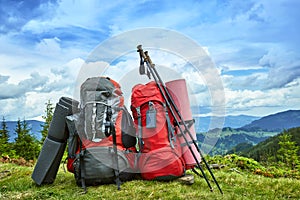 Backpacks in the mountains overlooking the mountains on the green grass.