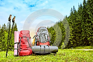 Backpacks in the mountains overlooking the mountains on the green grass.