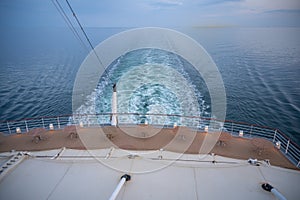 Backside of a cruise ship, sea during sunset, boat deck with waves