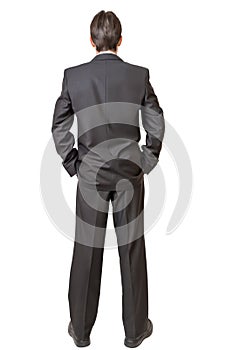 Backside of man in black suit keeping hands in pockets