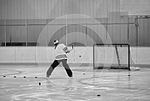 Backside of a man shooting pucks on a hockey net