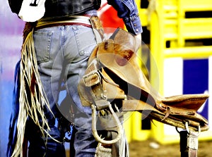 Backside of a Rodeo Cowboy with his Saddle photo