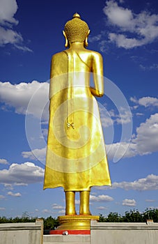 Backside of standing budha immage with blue sky