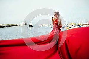 BAckside view of young gorgeous woman in long red dress