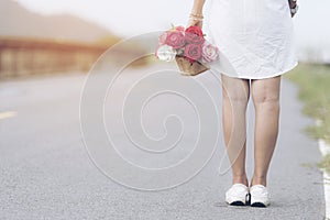 Backside of young woman holding Woman holding colorful bouquet in her hands on Summer day. Happy valentine day concept