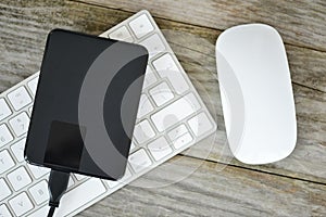 Backup data with external hard disk drive on white computer keyboard