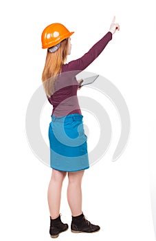 Backview of business woman in construction helmet with tablet p