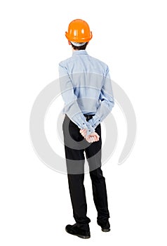 Backview of an engineer in construction helmet stands. photo