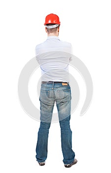 Backview of an engineer in construction helmet stands photo