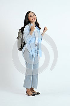 backview full leght shoot of happy asian Indonesian woman wearing casual attire and backpack on isolated background